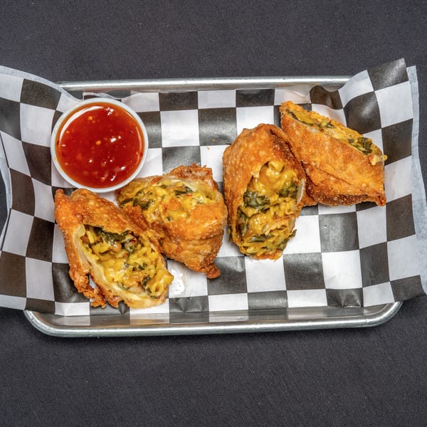 Four crispy egg rolls filled with macaroni and cheese, spinach, and beans, served with sweet chili sauce.