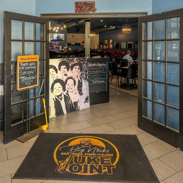 Entrance to Big Nicks Juke Joint with a welcome mat, open doors, and a glimpse of the dining area.